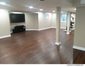 Spacious basement with hardwood flooring and TV.