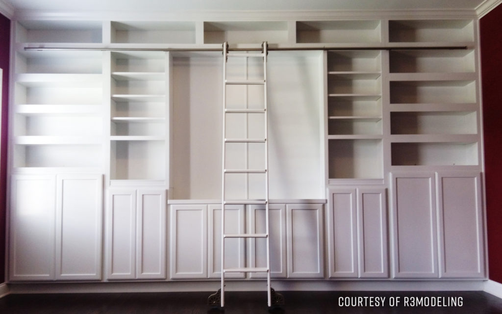 Empty white built-in shelves with a rolling ladder.