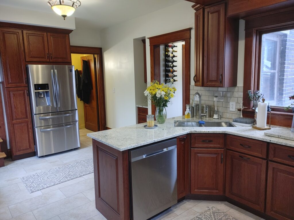 Modern kitchen with wooden cabinets and flowers.