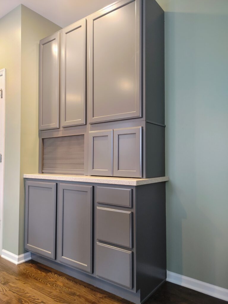 Gray kitchen cabinets with wooden floor.