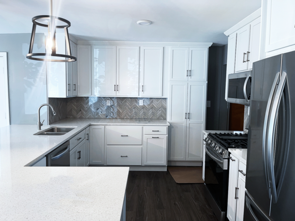 Modern kitchen with white cabinets and appliances.