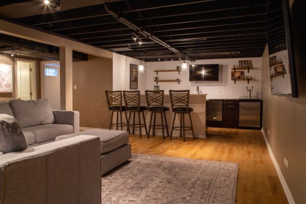 Modern basement with bar and seating area.