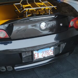 Black sports car with a custom fuel cap and visible license plate.