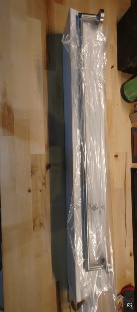 Stack of white plastic curtain tracks on a wooden surface.